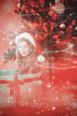 Poster - Composite image of festive little girl sitting in large gift