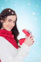 Poster - Composite image of smiling brunette opening christmas present