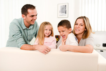 Wall Mural - happy cheerful family playing together in the sofa at home