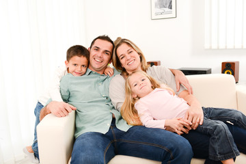 Wall Mural - happy cheerful family playing together in the sofa at home