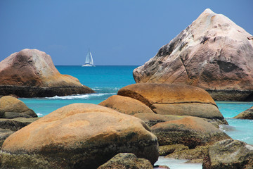 Beach in front of the Seychelles white sail boat sails off the c