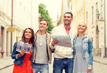 Canvas Print - group of smiling friends with city guide and map