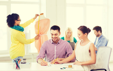 Canvas Print - smiling fashion designers working in office