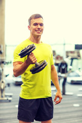 Wall Mural - smiling man with dumbbell in gym