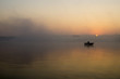 wędkarz na łodzi łowiący w mglisty poranek
