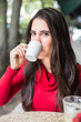 Portrait of happy beautiful brunette with mug in hand and drinki