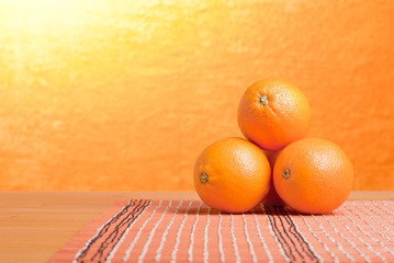 Beautiful ripe oranges on the table and a yellow orange backgrou