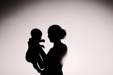 silhouette of mother and baby at sunset