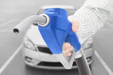 Blue Color Fuel Pump Gun In Hand With Car On Background