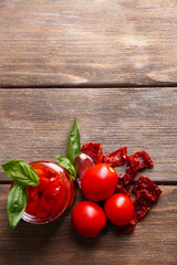 Wall Mural - Sun dried tomatoes in glass jar, basil leaves