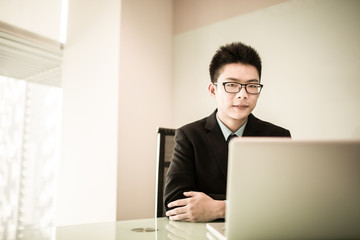 Wall Mural - Young handsome man using laptop in his office