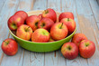 Verse appels in groene fruitschaal op oud hout