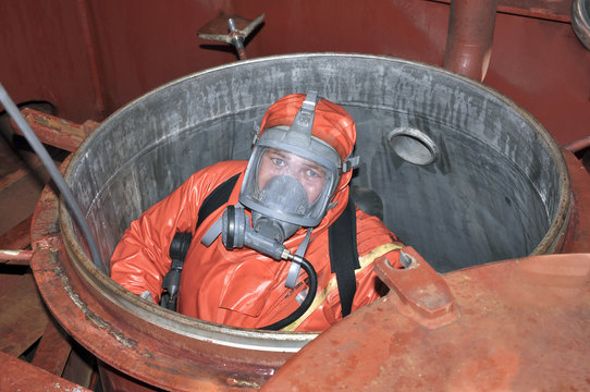 Fototapete - man in chemical suit entering inside cargo tank