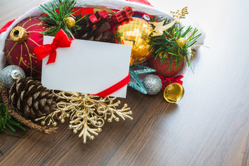 christmas card and santa hat with decorations on wooden backgrou