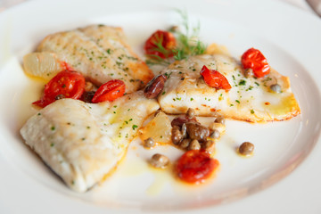 Fried fish fillet with capers and tomatoes