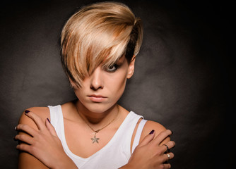 Blonde girl with a short stylish haircut on a dark background