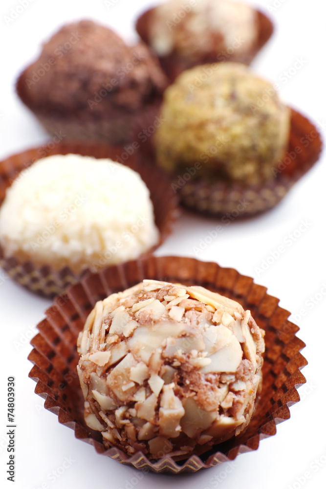 Sweet round candy wrapped in paper bowl on white background