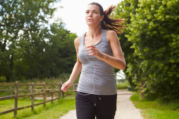 Woman Running In Countryside Wearing Earphones