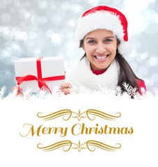 Poster - Composite image of festive brunette holding gift