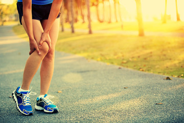 Wall Mural - woman runner hold her sports injured knee 