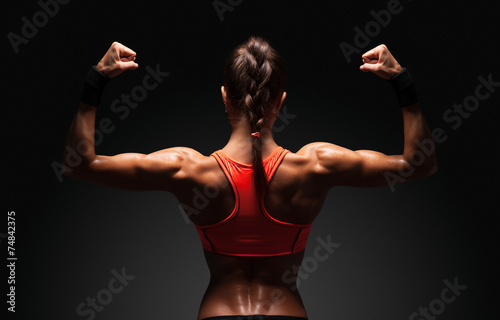 Cuadros en Lienzo Athletic young woman showing muscles of the back