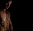 © M-Production - Muscular male model on black background. Place for your text.