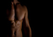 © M-Production - Unrecognizable muscular male body on black background.