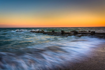 Waves and a jetty at sunset in the Atlantic Ocean at Edisto Beac