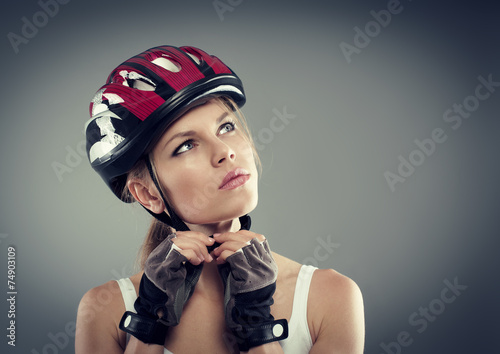 Fototapeta dla dzieci Cycling. Female putting biking helmet before ride.