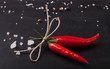 three related twine red hot peppers on a blackboard. With space