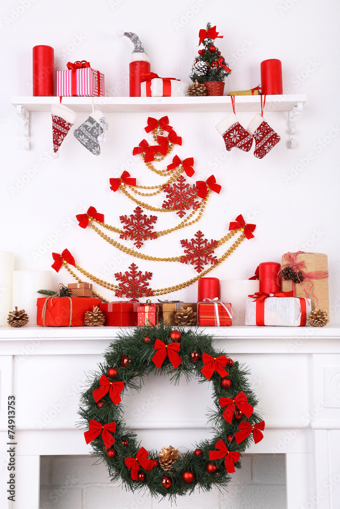 Christmas decorations on mantelpiece on white wall background
