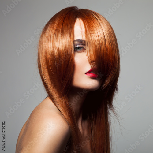 Foto Beauty model with perfect long glossy red hair. Close-up portrai