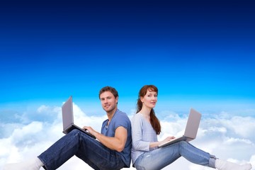 Poster - Composite image of couple both using laptops separately
