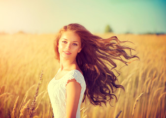 Beautiful teenage model girl in white dress enjoying nature