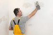 © sima - Worker repairing plaster at wall with trowel