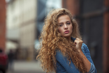 Beautiful young girl with thick long curly hair outdoors