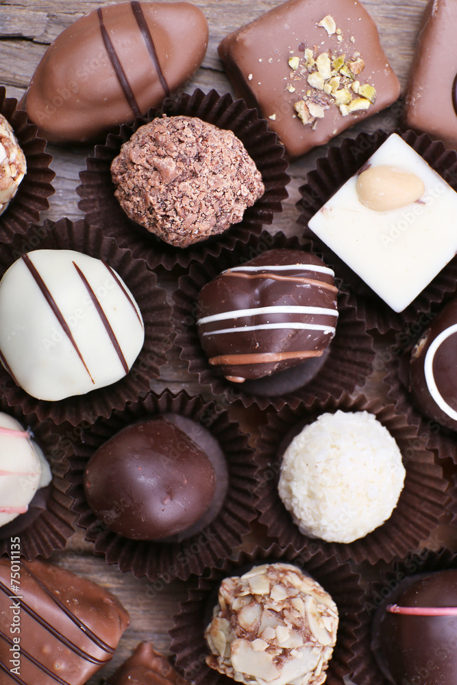 Many chocolates on wooden textured background