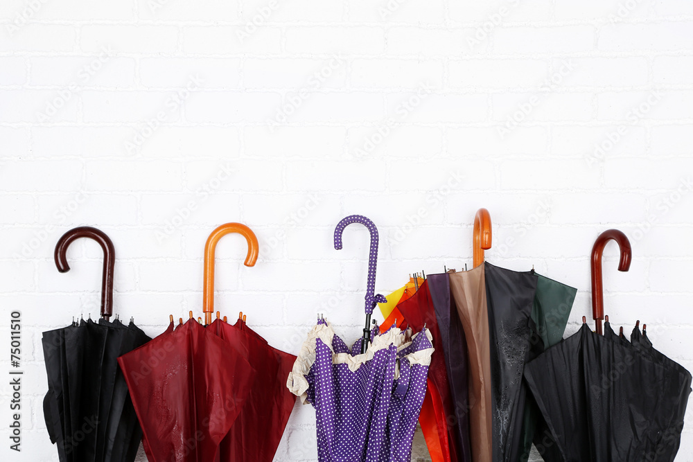 Bright umbrellas leaning against a bricks wall