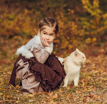 Cute Girl With A Cat In Vintage Clothes In Autumn Forest