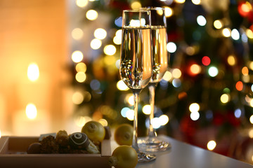 Two glass with champagne with chocolates and baubles