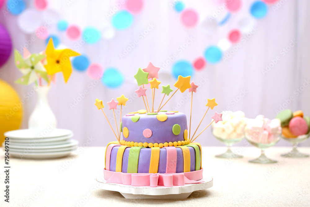 Delicious birthday cake on table on bright background