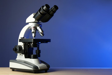 Wall Mural - microscope on table, on color background