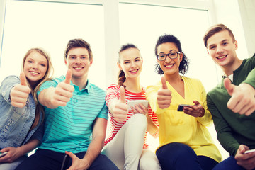 Wall Mural - smiling students with smartphone texting at school