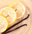 Dried slices of lemon with vanilla beans on wooden background