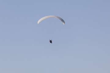 Paraglider against blue sky