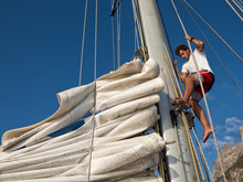 Young Man Working On Mast Of Sailing Ship