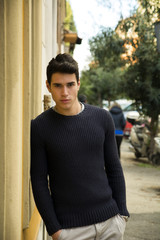 Wall Mural - Handsome young man standing in European city street