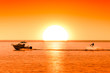 © Pavel Burchenko - silhouette of boat and wakeboarder at sunset