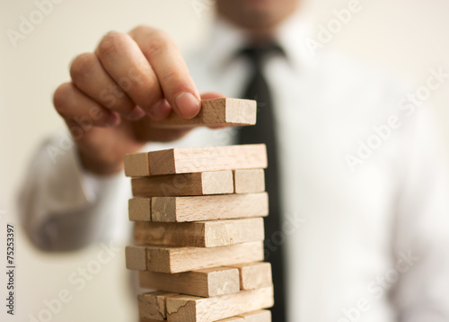 Fotografía Businessman putting last block to the tower