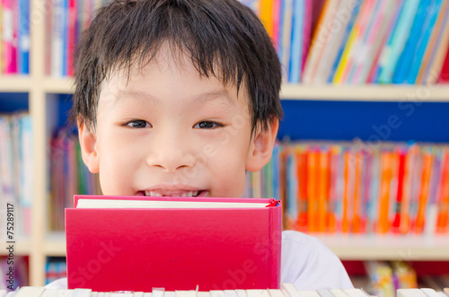 Fotografia Asian boy student reading book in school library